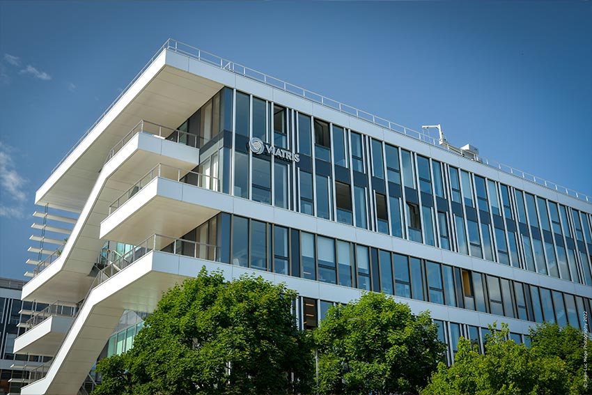 Bâtiment de bureaux contemporain avec façade vitrée et logo Viatris visible.