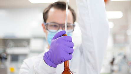 Scientifique travaillant dans un laboratoire sur notre site de Châtillon-sur-Chalaronne, utilisant une pipette et un tube à essai