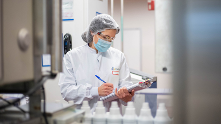 Scientifique remplissant un tube à essai sur notre site Viatris à Meyzieu