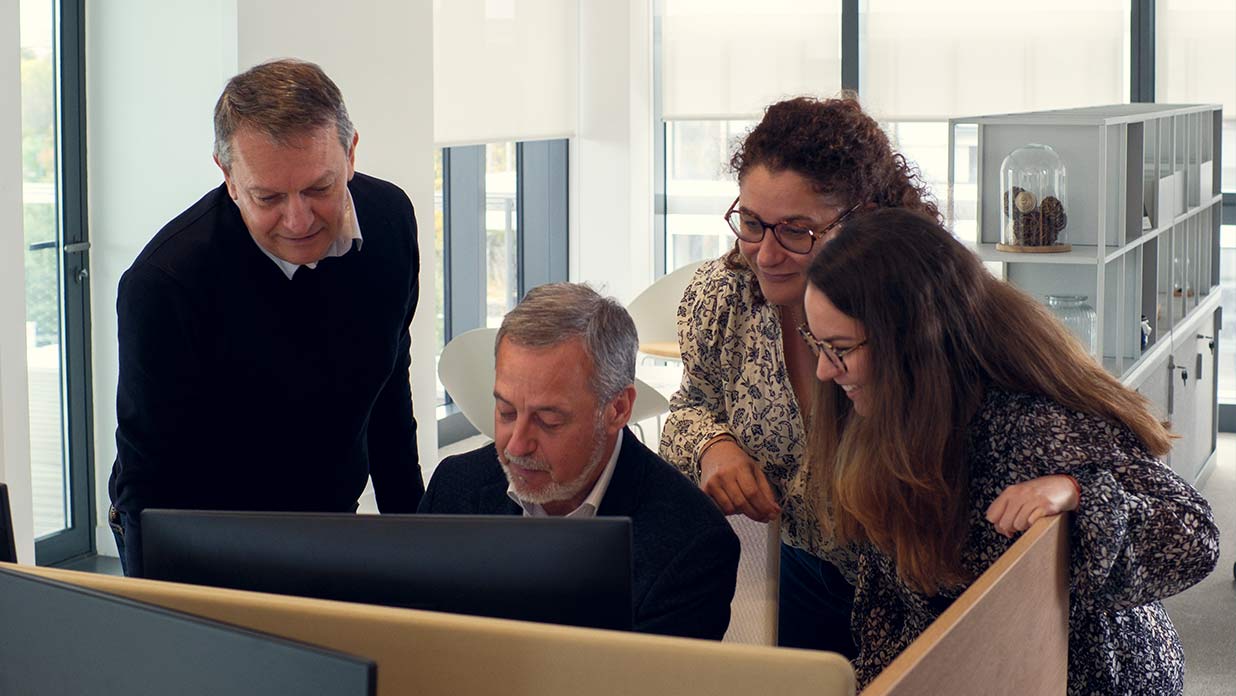 Plusieurs collaborateurs Viatris sont rassemblés derrière un ordinateur, dans nos bureaux à Lyon