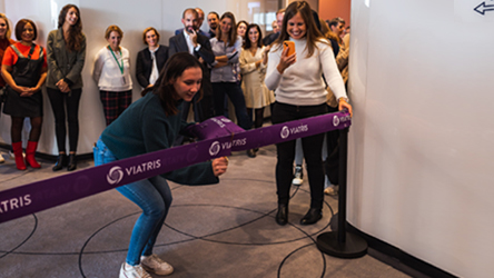 Une collaboratrice inaugure les locaux de Viatris à Paris en coupant un ruban